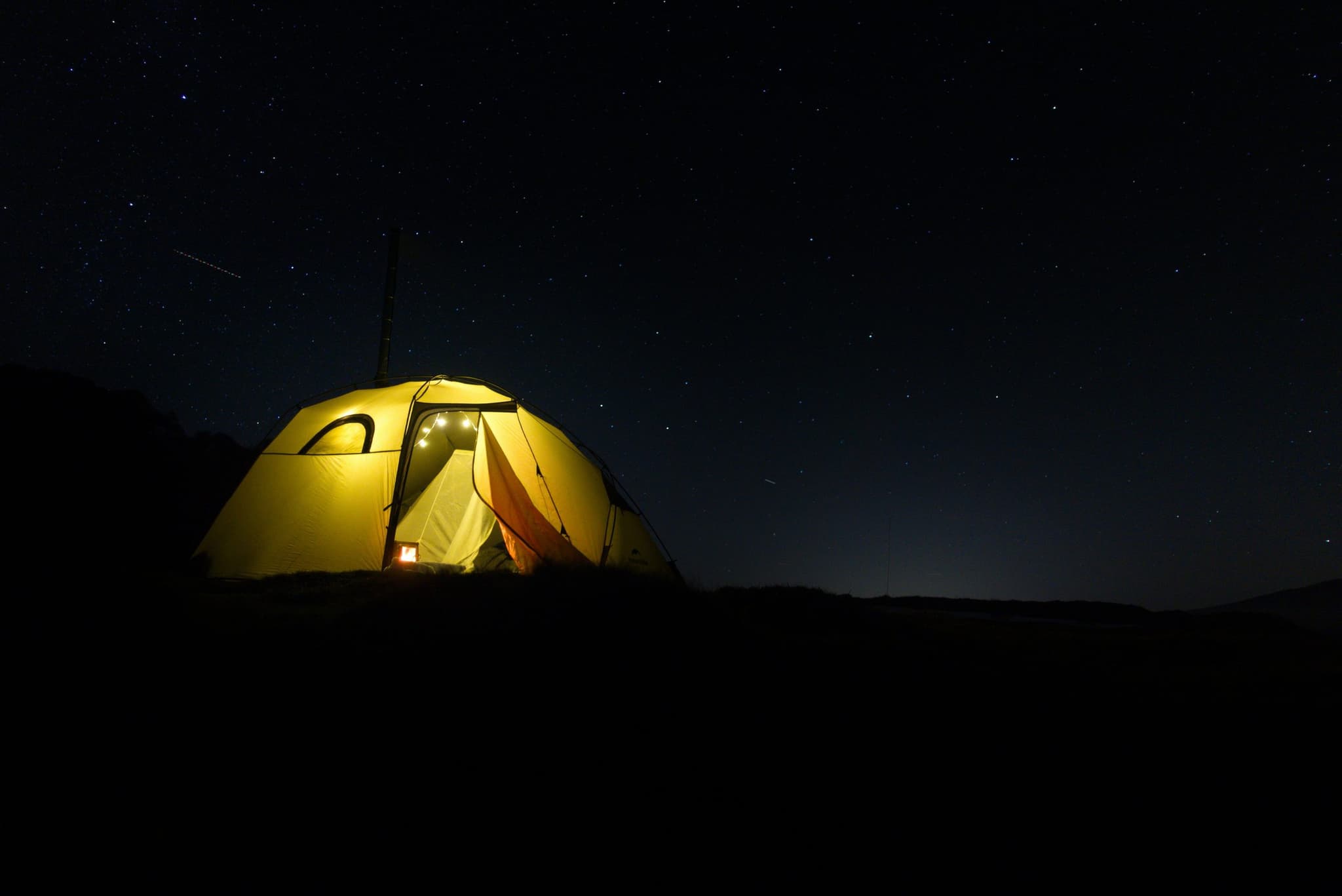A glowing tent beneath the night sky